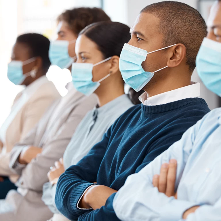 A Moderately-Sized Employer Standing Beside Employees w/ Masks On During COVID-19